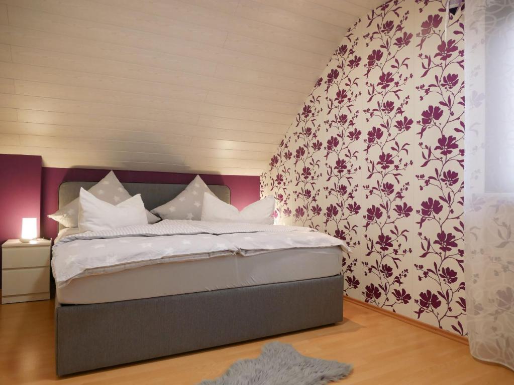 a bedroom with a large bed with a floral wallpaper at Ferienwohnung Eva-Maria in Mahlberg