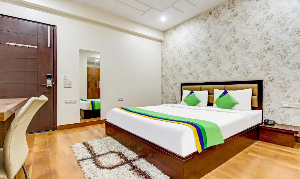 Postel nebo postele na pokoji v ubytování Treebo M2M Residency Sector 46