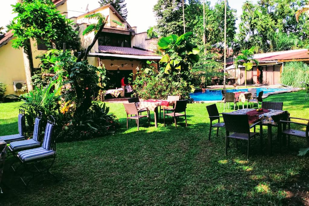 a yard with chairs and tables and a pool at Le 159 in Kinshasa