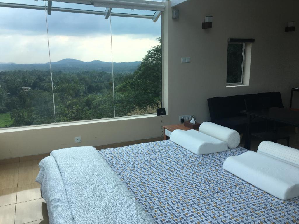 een slaapkamer met een bed en een groot raam bij Sky Retreat - Sri Lanka in Gampaha