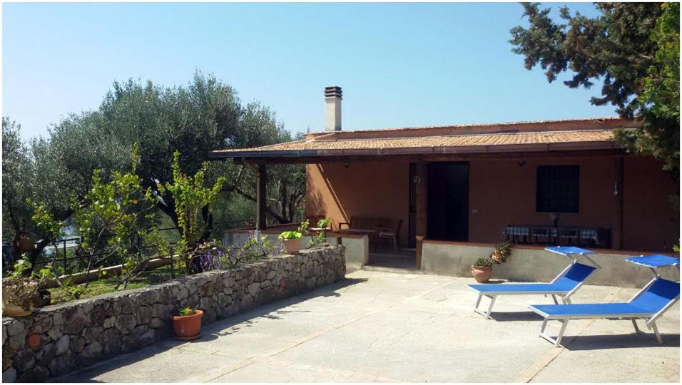eine Terrasse mit zwei blauen Stühlen und einem Gebäude in der Unterkunft Villetta Fenosa in Marina di Camerota