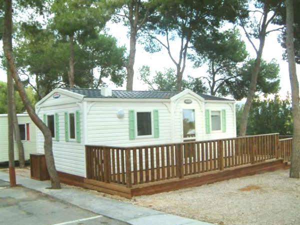 a small white house with a wooden fence at Camping Moraira in Moraira