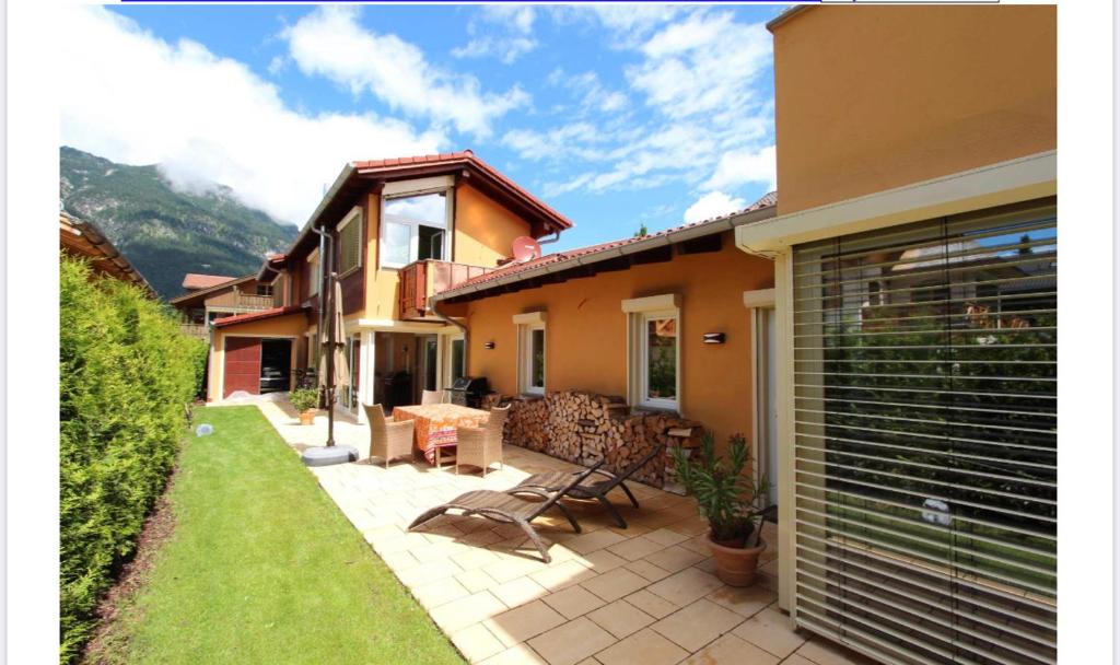 dom z patio ze stołem i krzesłami w obiekcie Alpine Escape Holiday Home with Mountain View w Garmisch Partenkirchen