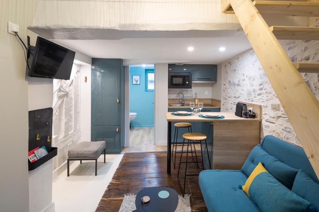 雷恩的住宿－Ty Color's，一间带蓝色沙发的客厅和一间厨房