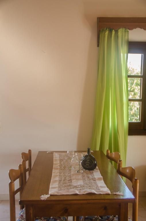 a dining room table with a green curtain at Takis Apartments in Sidari
