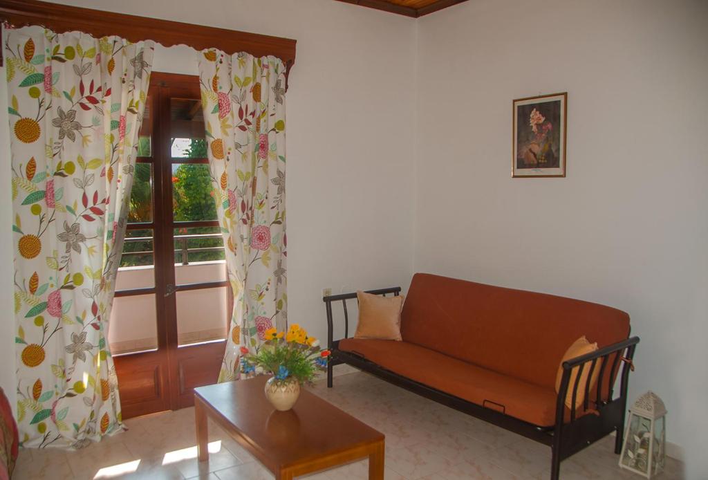 a living room with a couch and a window at Takis Apartments in Sidari