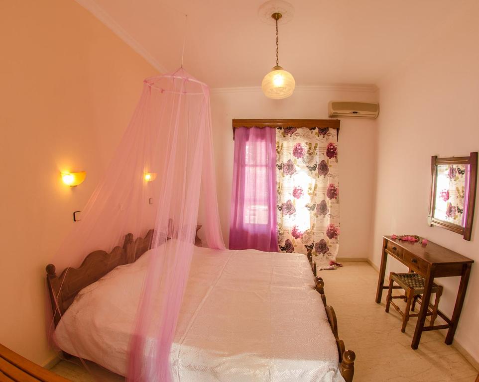 a bedroom with a bed with a mosquito net at Takis Apartments in Sidari