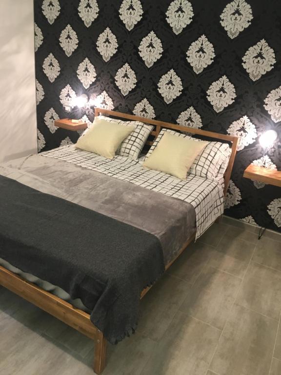 łóżko z 2 poduszkami i czarno-białą ścianą w obiekcie Dost w mieście Palermo