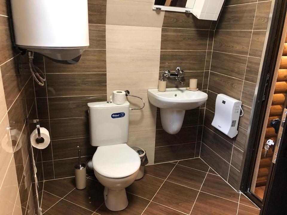 a bathroom with a toilet and a sink at Belvedere Villas in Dospat