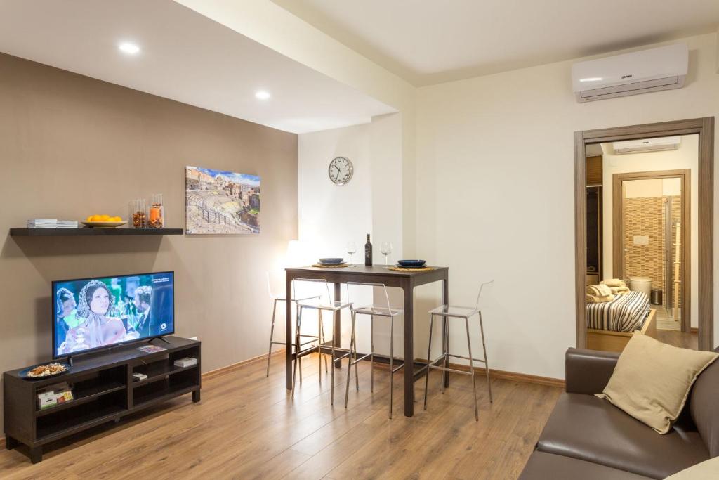 a living room with a table and a tv at Dimora delle Sciare - Centro Storico in Catania