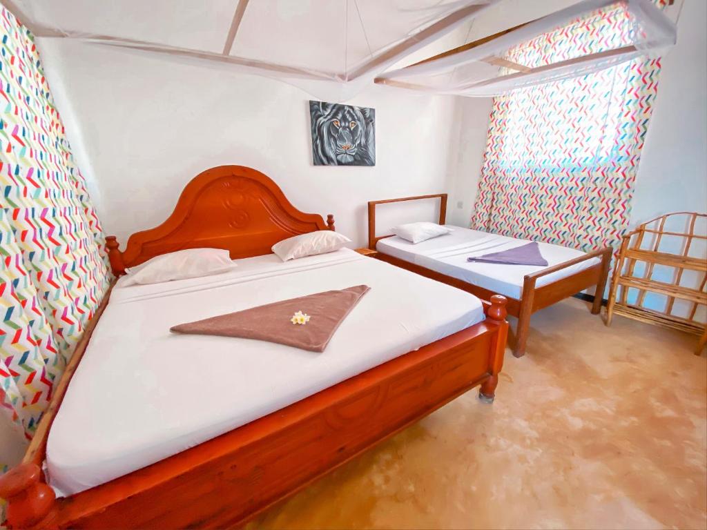 Postel nebo postele na pokoji v ubytování Papaya Guest House Nungwi