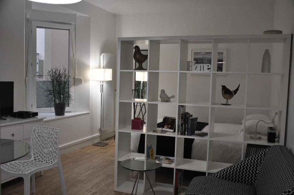 a living room with a book shelf with items on it at LE NID DES HALLES, au cœur du Boulingrin in Reims