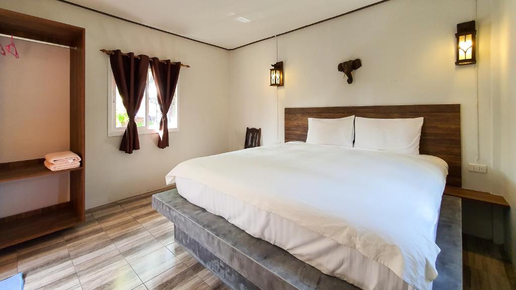 a bedroom with a large bed and a window at Harrys Sunset - Klong Nin Beach in Ko Lanta