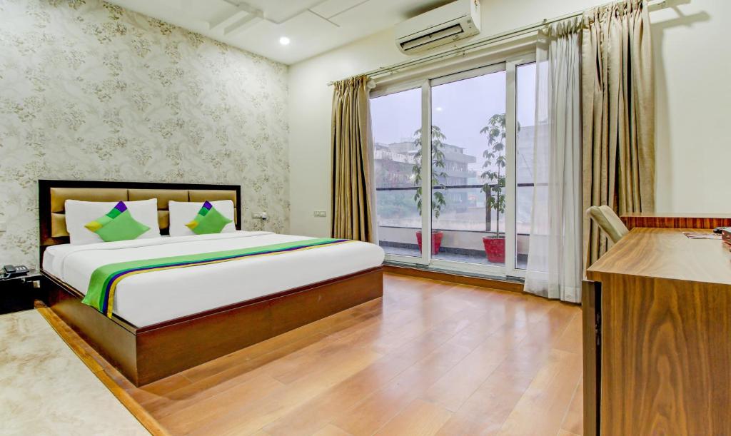 - une chambre avec un lit et une grande fenêtre dans l'établissement Treebo Trend M2M Residency Sector 46, à Gurgaon