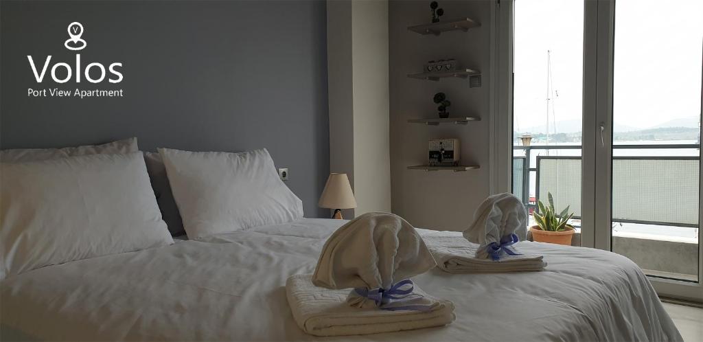 Volos Port View Apartment في فولوس: غرفة نوم عليها سرير وفوط