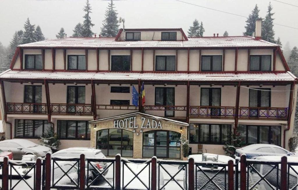 a large building with cars parked in front of it at Hotel Zada in Predeal