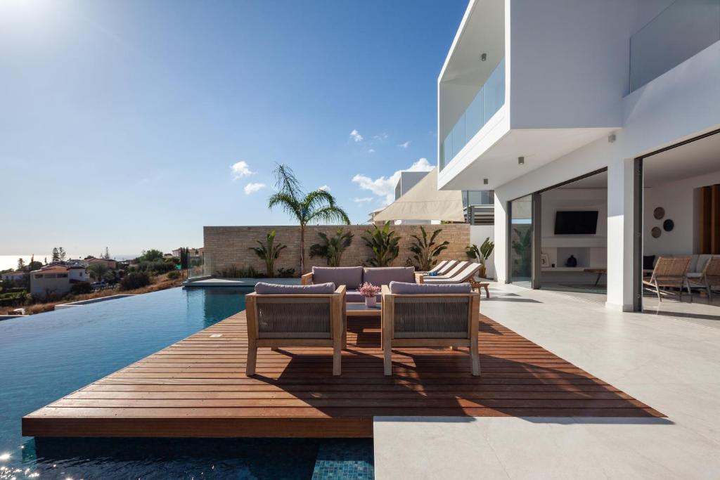 a patio with two chairs and a table and a pool at Thalassa in Paphos City
