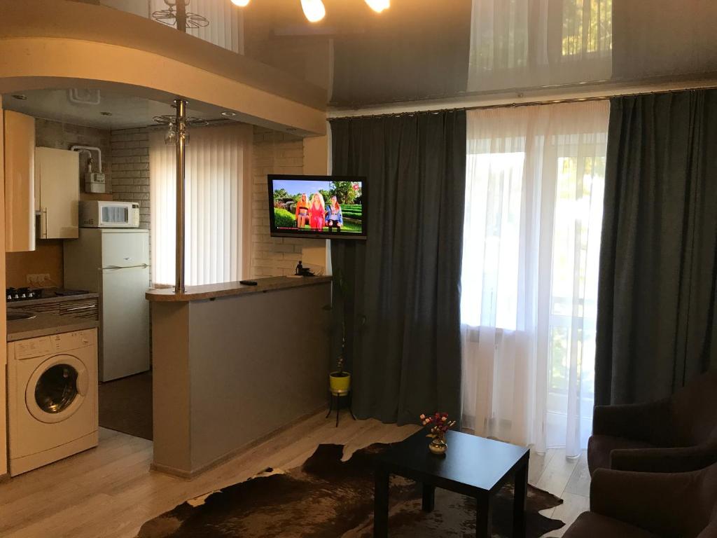 ein Wohnzimmer mit einer Küche und einem TV im Zimmer in der Unterkunft Квартира Апполо in Dnipro