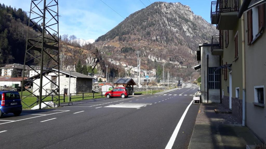 an empty street with a mountain in the background at Residenza Al Ponte in Branzi