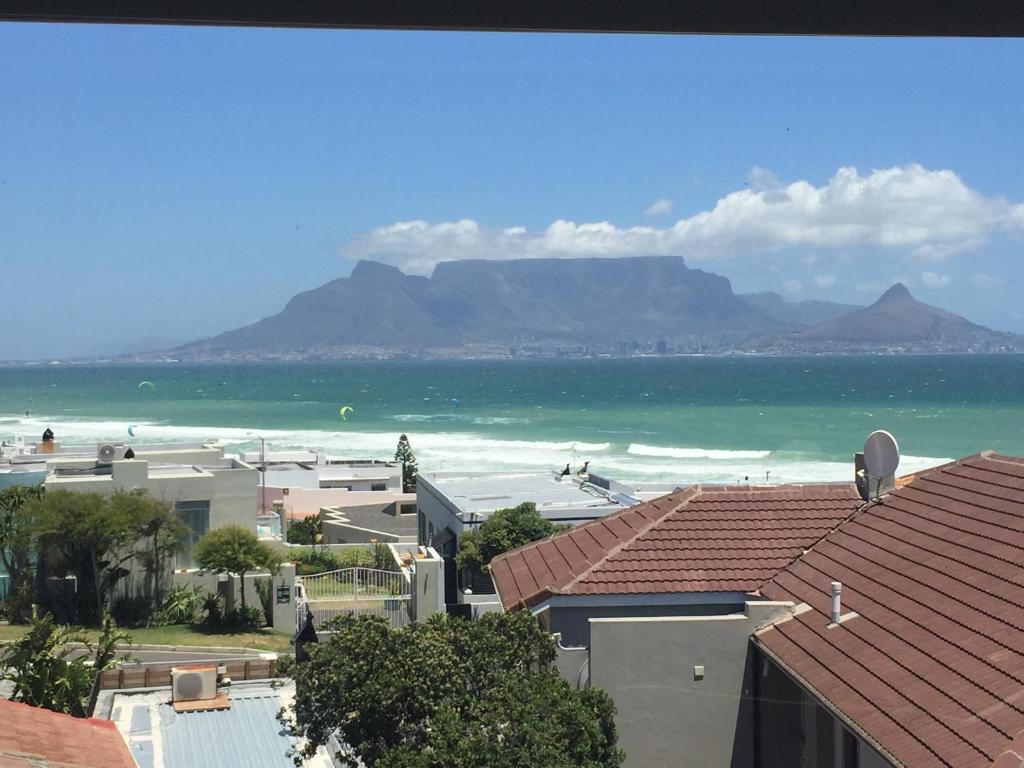a view of the beach with mountains in the background at Gull on the Bay Boutique Guest House in Bloubergstrand