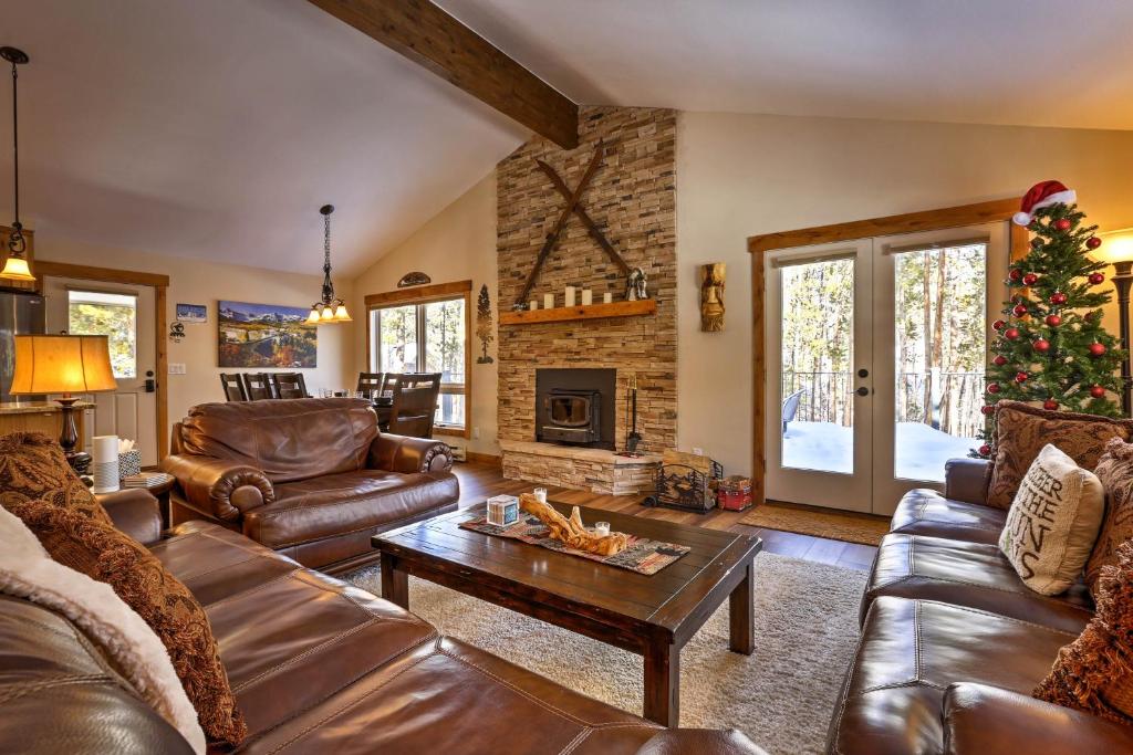 a living room with leather furniture and a christmas tree at Keystone Home on Snake River with Hot Tub and Views! in Keystone