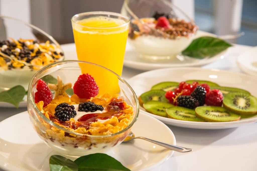 a table with plates of breakfast food and a bowl of fruit at Ibis Styles Nice Centre Gare in Nice