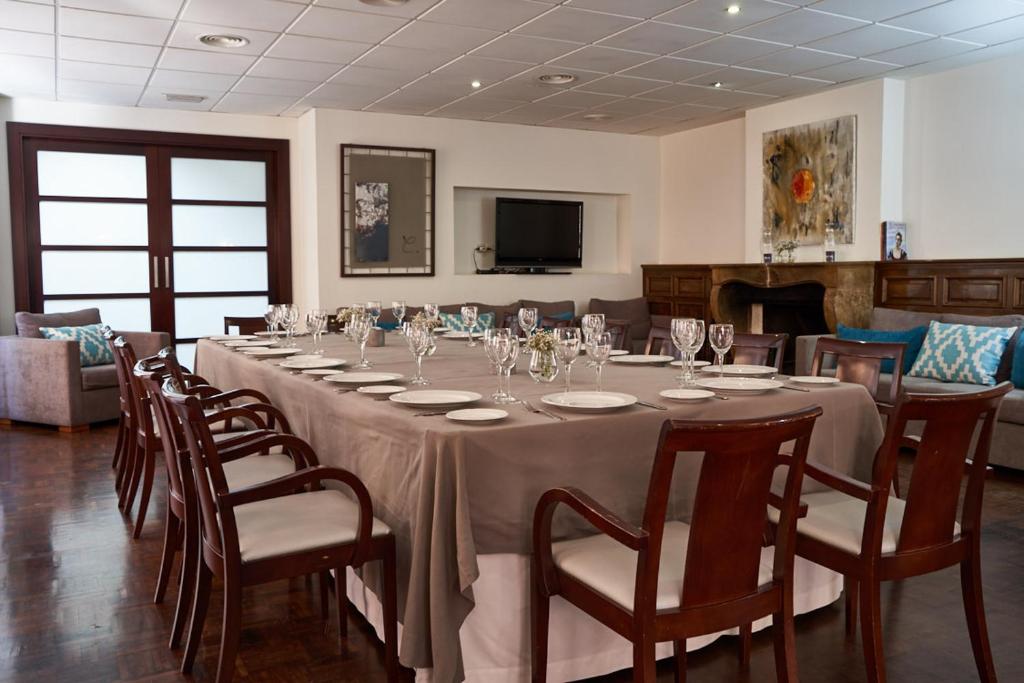 comedor grande con mesa larga y sillas en Hotel Don Curro, en Málaga