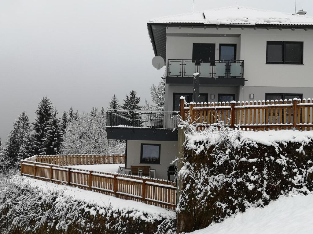 ein Haus mit einer Terrasse im Schnee in der Unterkunft Appartement Franz in Zell am Ziller