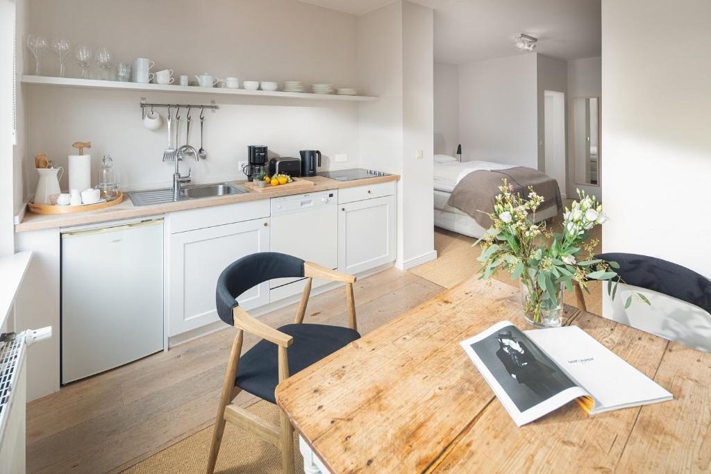 a kitchen and dining room with a wooden table and chairs at Friedrich Inn in Norderney