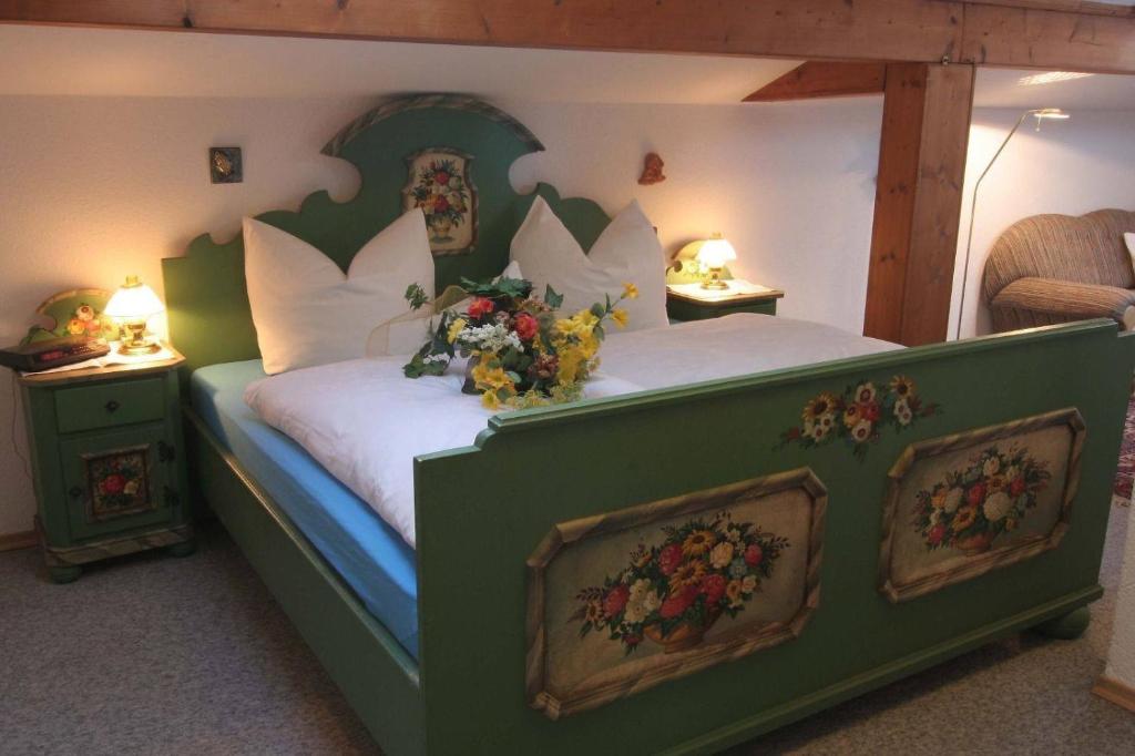 ein Schlafzimmer mit einem großen Bett mit Blumen darauf in der Unterkunft Hotel 4 Jahreszeiten mit Restaurant in Albstadt