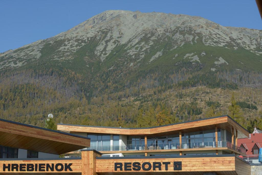 a resort building with a mountain in the background at Apartman D304 in Starý Smokovec