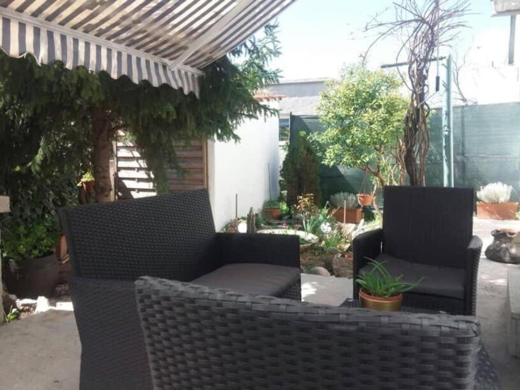 a patio with two wicker chairs and a pergola at Holiday Home Spalato in Split