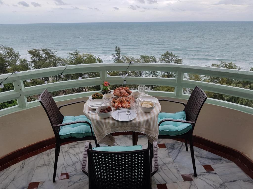 a table on a balcony with the ocean in the background at Panorama Sea View Room 245, V.I.P Condo Chain Rayong in Ban Phe