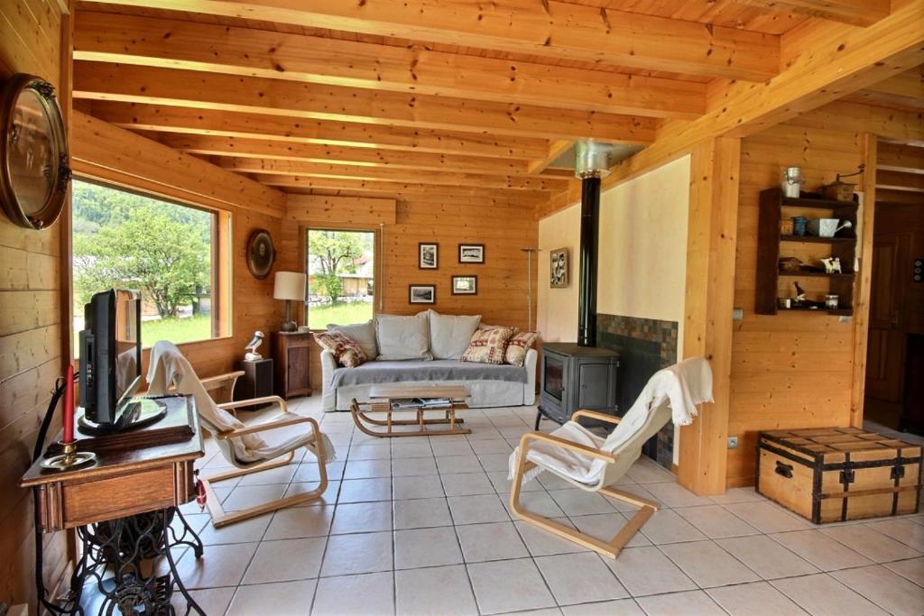 een woonkamer met een bank en een open haard bij CHALET WIFI - LE BIOT - 8 PERSONNES - CHALET MORAND in Le Biot