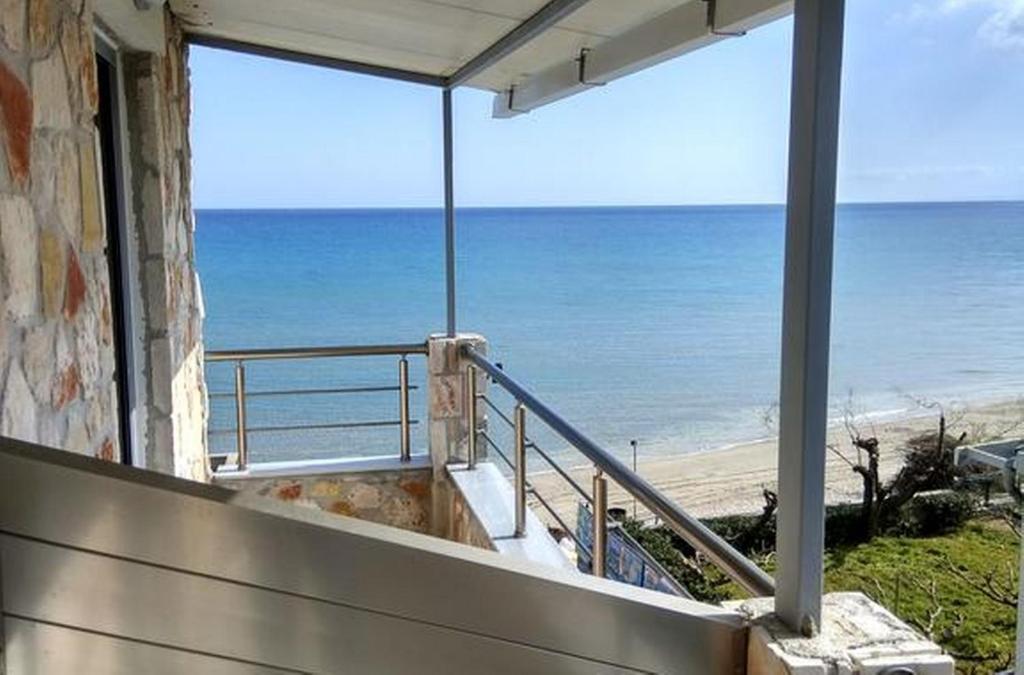 a balcony with a view of the beach at Golden Dolphin Studios & Apartments in Alykes