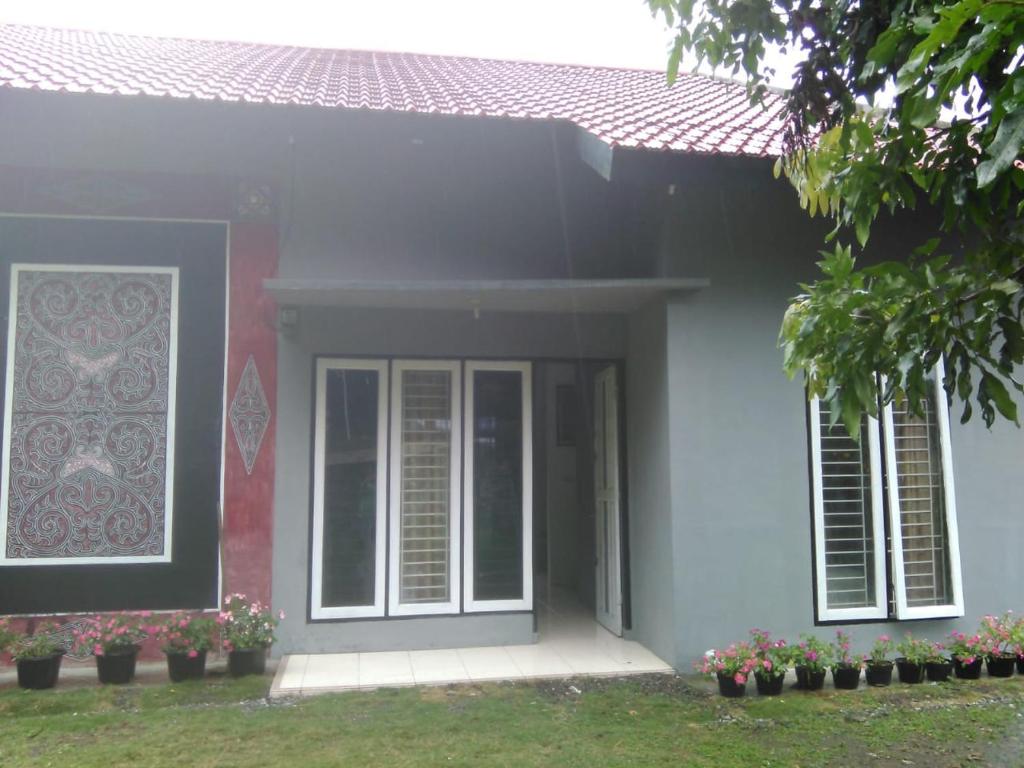 una casa con una puerta, ventanas y flores en Villa Sahala Simanjuntak, en Balige