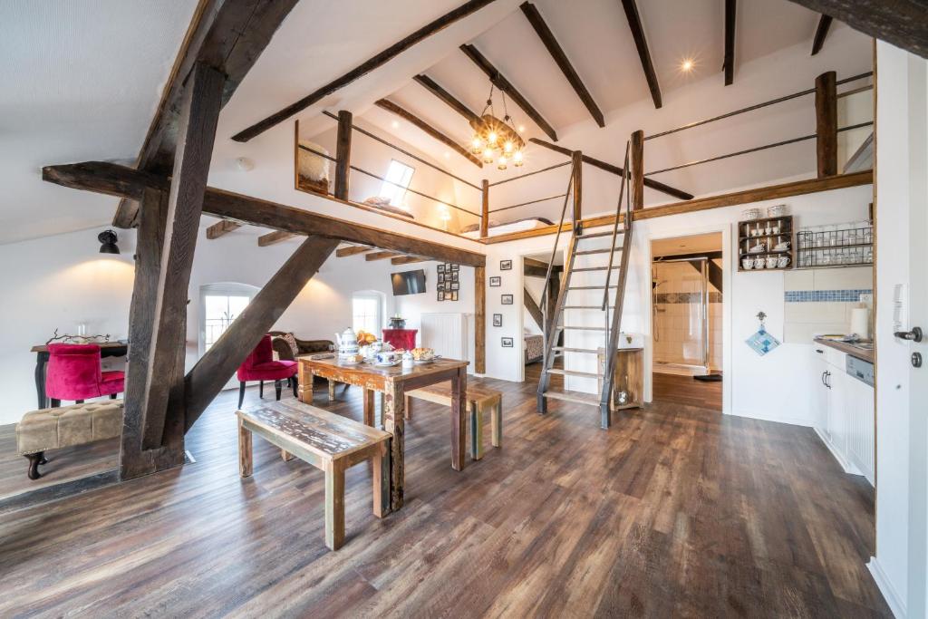 a living room with wooden floors and a loft with a ladder at Ostland-Loft in Borkum