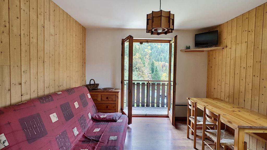 un salon avec un canapé, une table et une fenêtre dans l'établissement APPARTEMENT ST JEAN D'AULPS - PROCHE MORZINE - PIED DES PISTES - Moussière 8, à Saint-Jean-dʼAulps