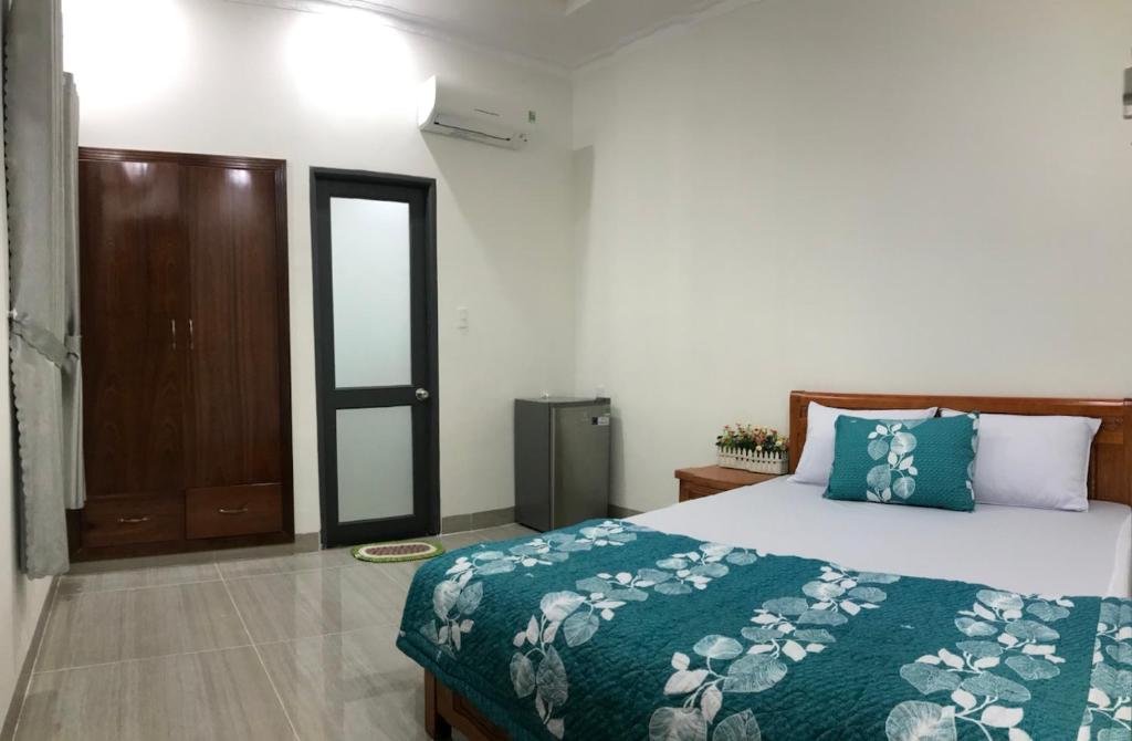 een slaapkamer met een bed met een groene sprei bij Motel Thân Thiện 2 in Vung Tau
