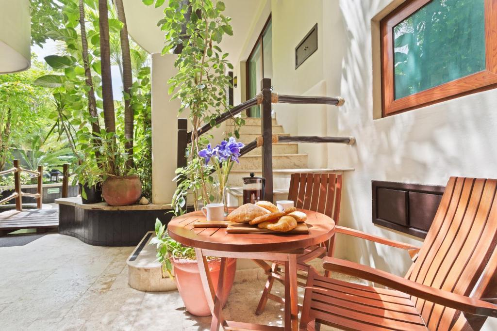 a table with a plate of bread sitting on a porch at El Taj Oceanfront and Beachside Condo Hotel in Playa del Carmen