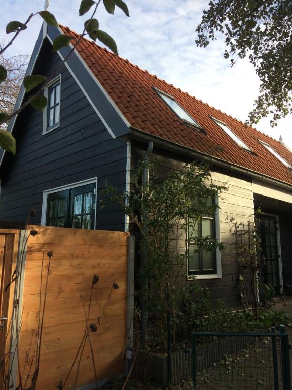 una casa con una valla de madera delante de ella en het zwaluwnest, en Koudekerke