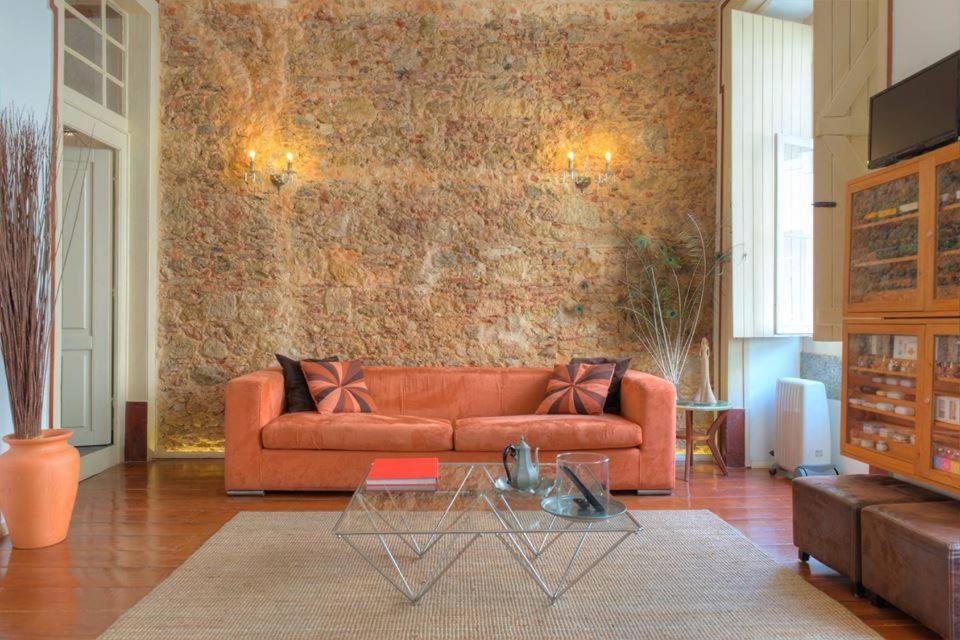 a living room with a orange couch and a table at Brand New in Heart of Lisbon in Lisbon