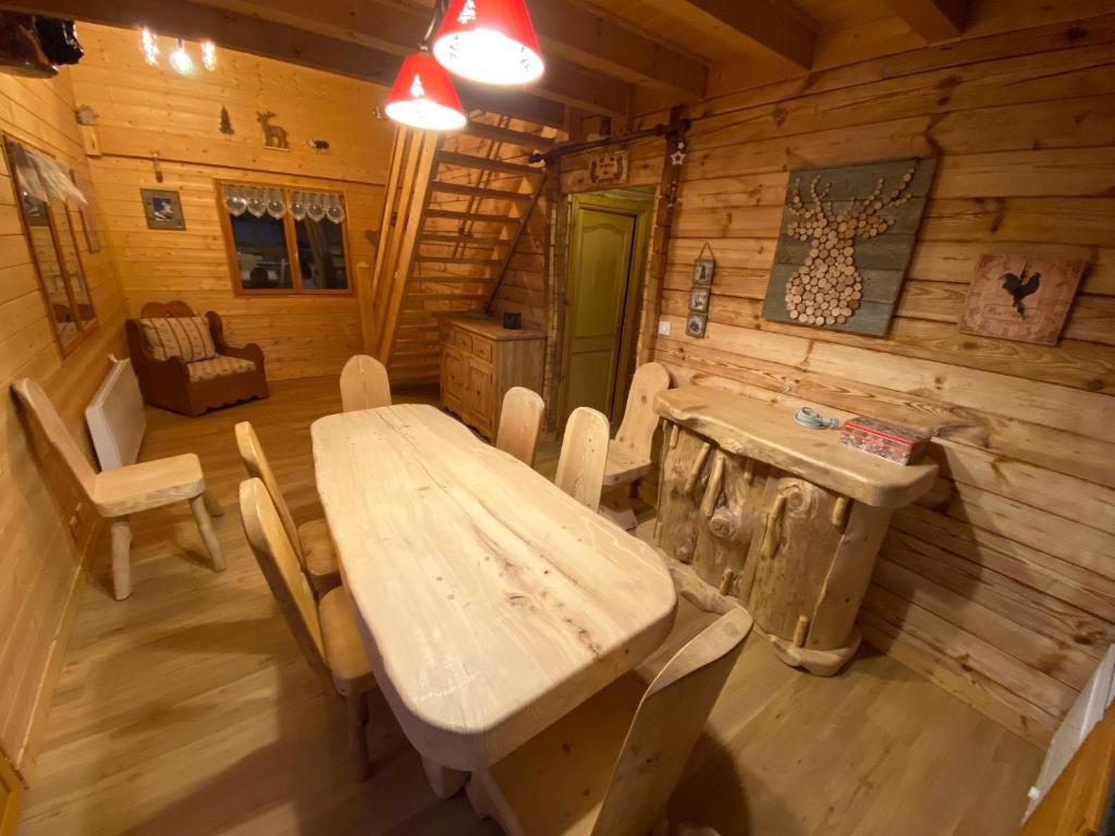 a dining room with a table and chairs in a cabin at le refuge des Marmottes in Saint-Laurent-du-Jura