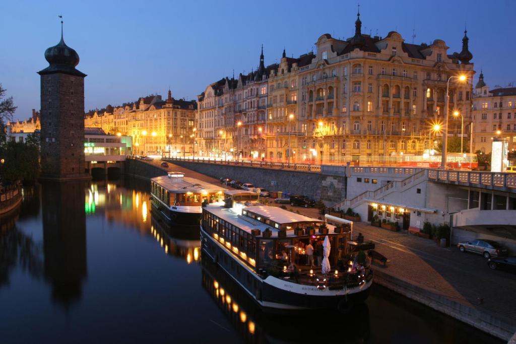 kilka łodzi w rzece w nocy w obiekcie Boat Hotel Matylda w Pradze