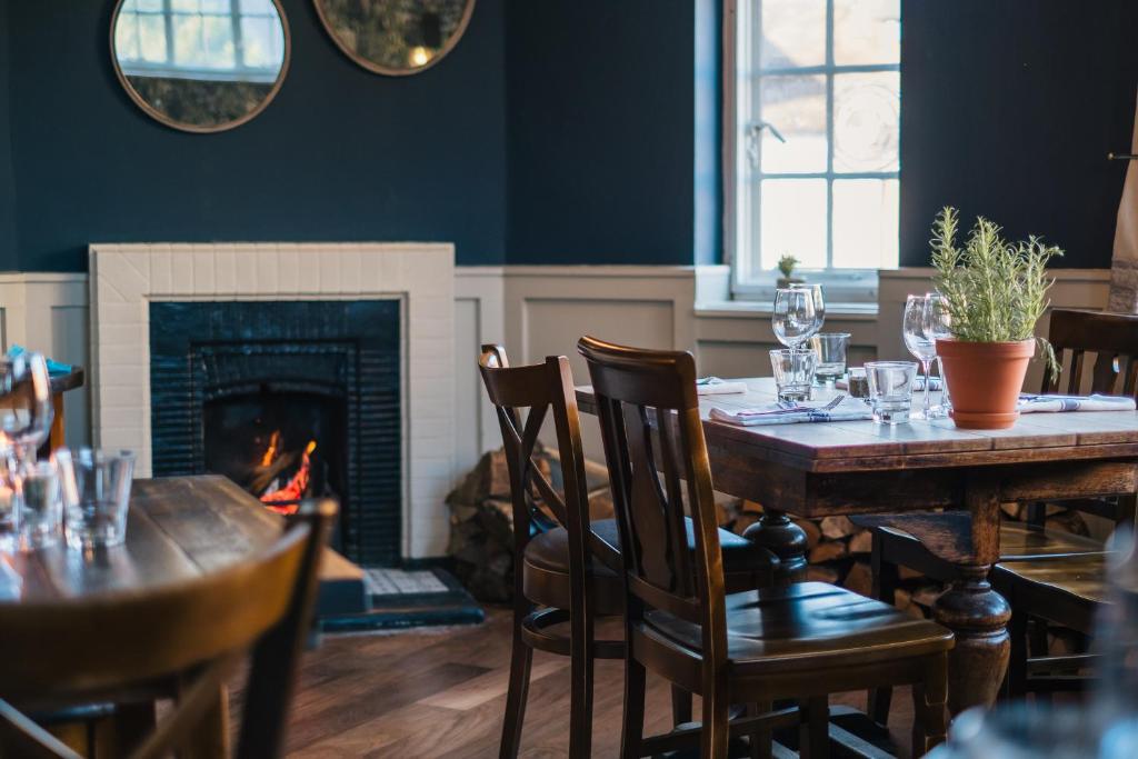 a dining room with a table and a fireplace at The Black Boy in Oxford