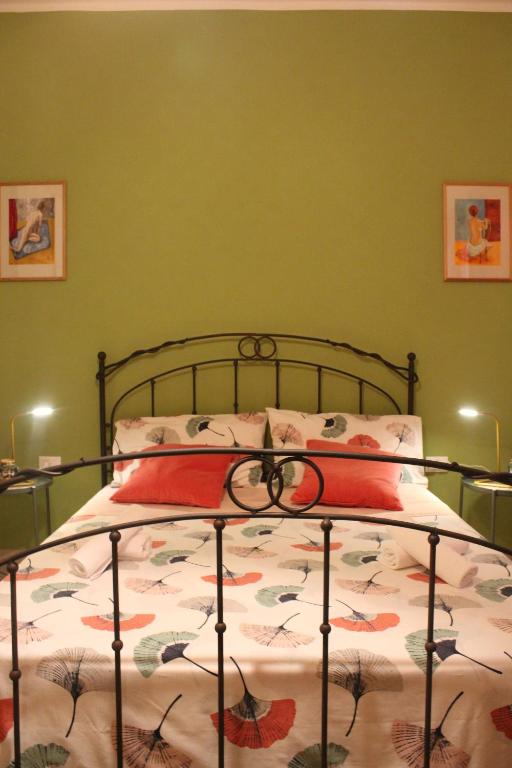 un letto in una camera da letto con pareti verdi di La Melagrana ad Arenella