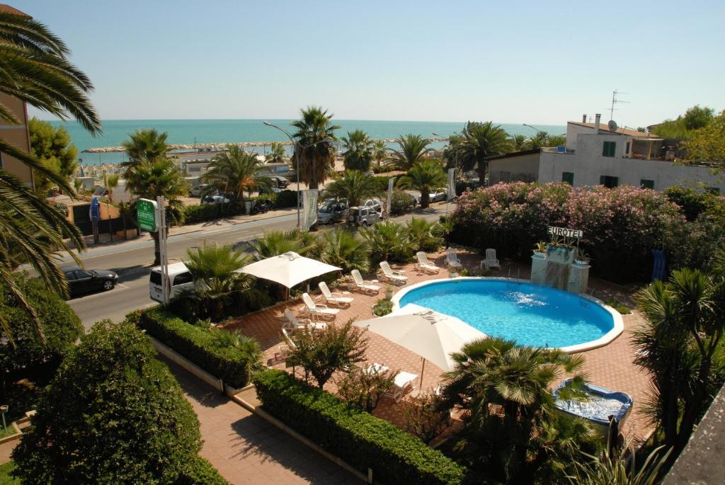 a view of a resort with a pool and chairs at Eurotel in Grottammare