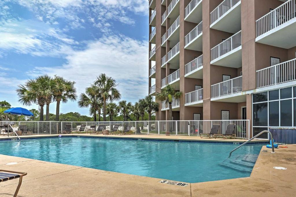 a swimming pool in front of a apartment building at West Gulf Shores Condo with Ocean Views, Shared Pool in Gulf Shores