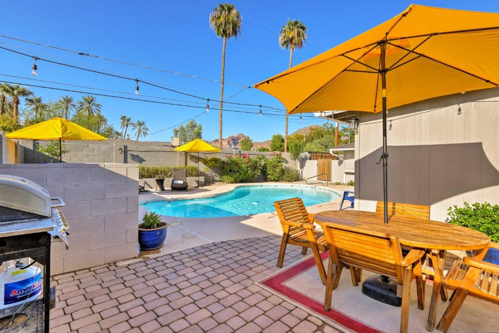 stół i krzesła z parasolami oraz basen w obiekcie Phoenix Home with Pool and Camelback Mtn Views! w mieście Phoenix