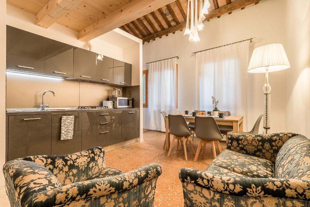 ein Wohnzimmer mit 2 Stühlen und eine Küche in der Unterkunft VENETIAN NEW STYLE @ CA' D'ORO in Venedig